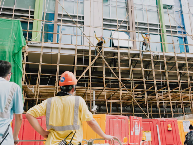 Worker in a high-visibility vest and hard hat on scaffolding