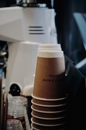 Close-up of eco-friendly cardboard cups stacked neatly in a bright industrial workshop.