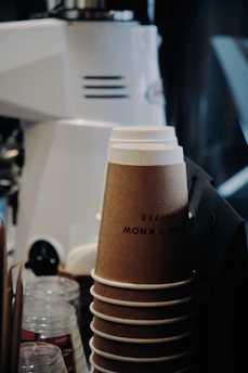 Stacked personalized coffee mugs and bottles ready for delivery.