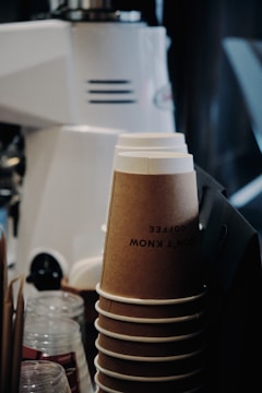 Close-up of eco-friendly cardboard cups stacked neatly in a bright industrial workshop.