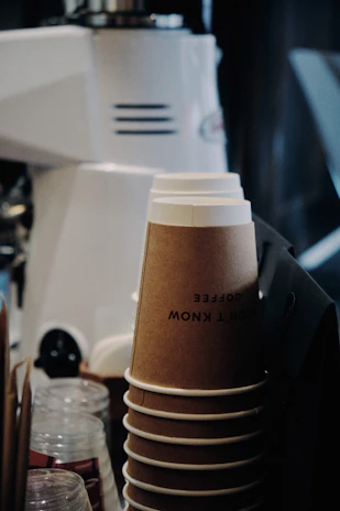 Photo of a modern factory workspace with stacks of paper cups and containers ready for shipment.