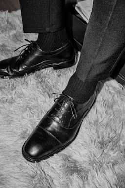 a pair of black shoes on a carpet