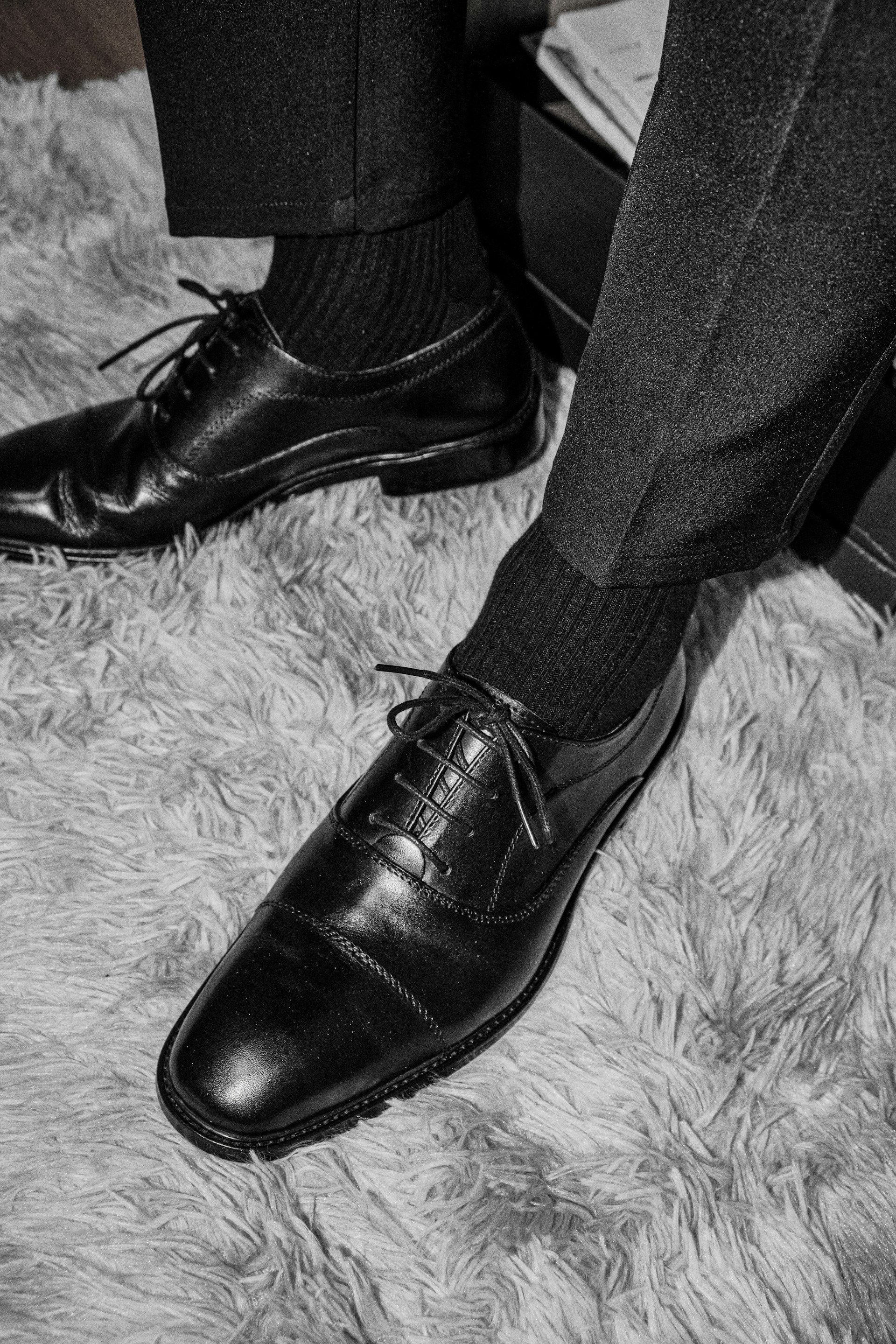 a pair of black shoes on a carpet