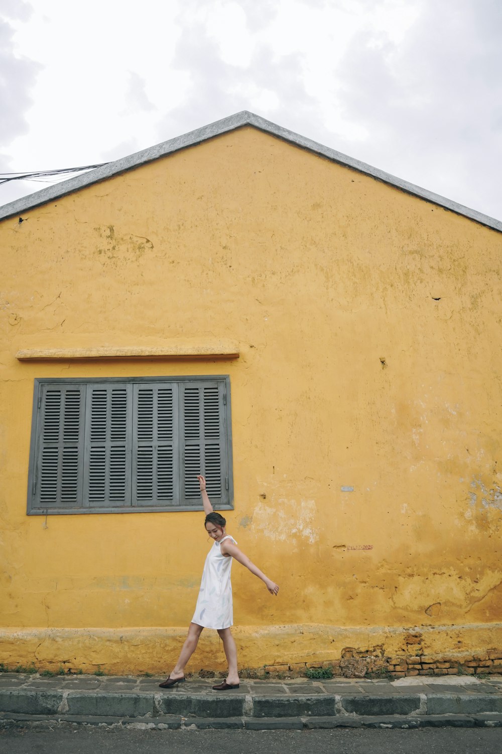 a man standing in front of a yellow building