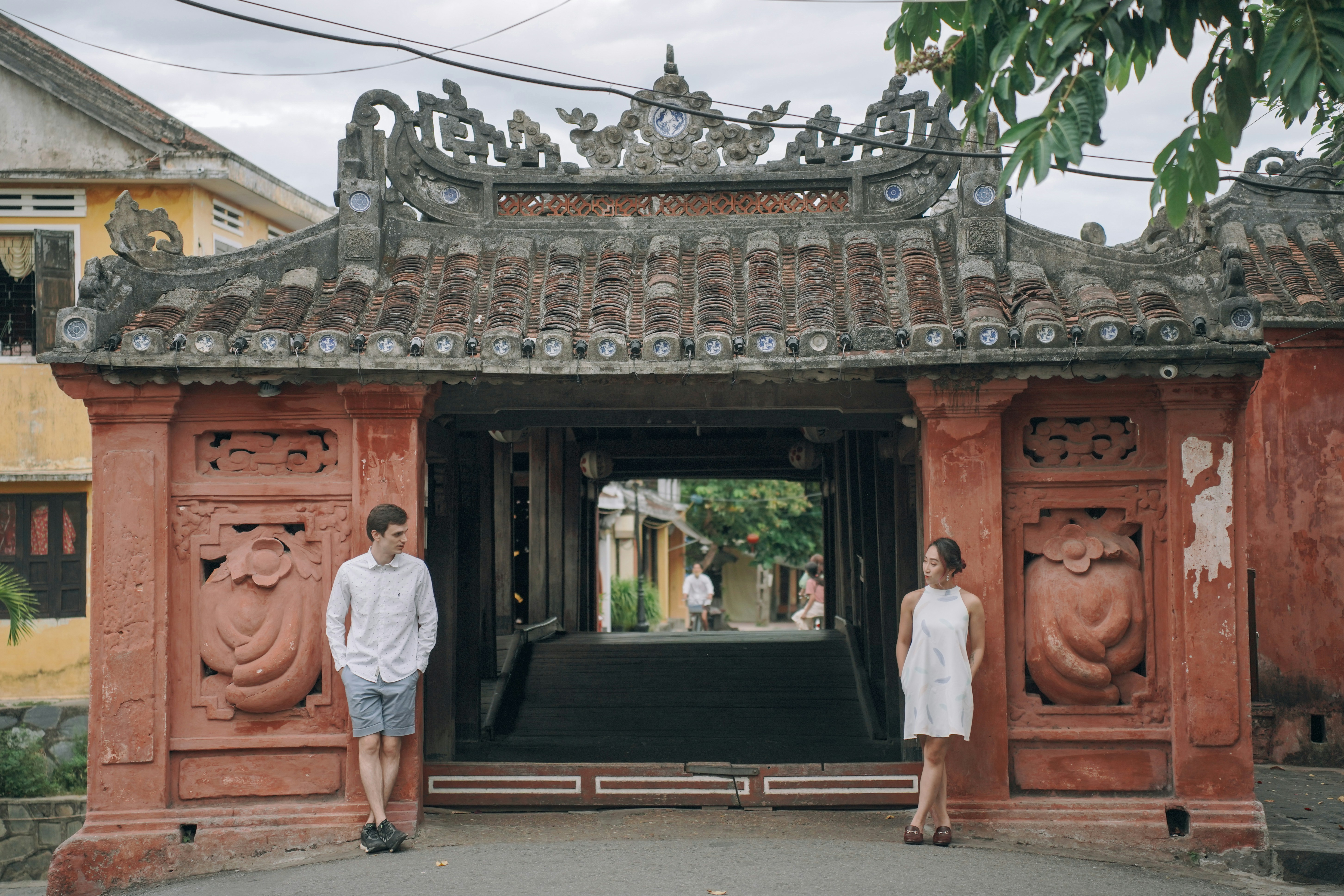 a couple walking in front of a building with a large statue