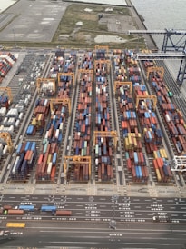 Workers operating forklifts and trucks moving containers smoothly in a busy logistics yard.