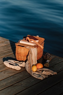 Close-up of a picnic basket filled with fresh local products on the deck of a boat.