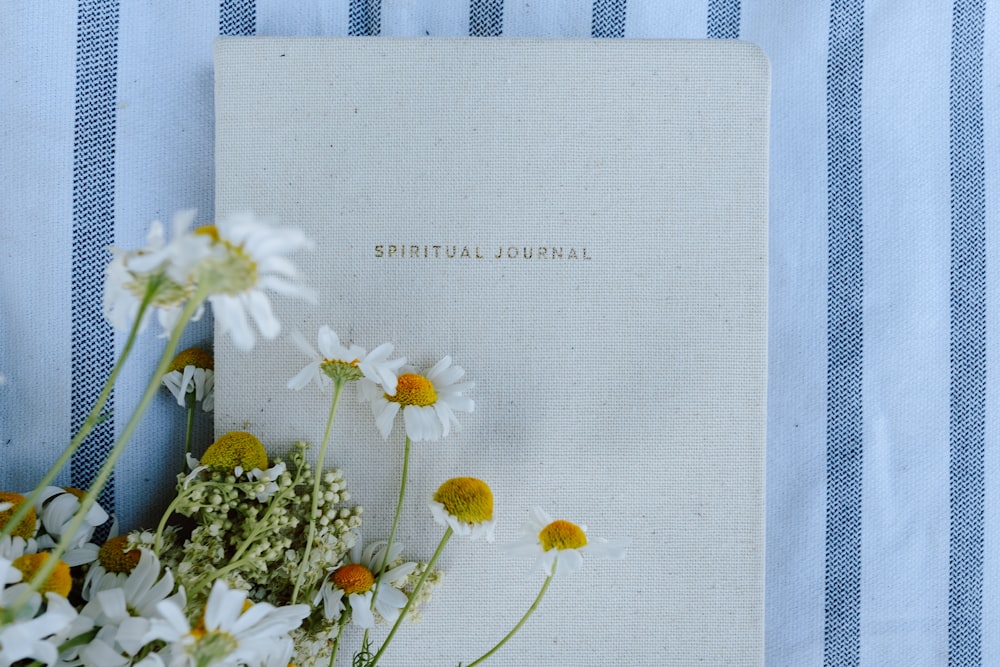 a white book with yellow flowers