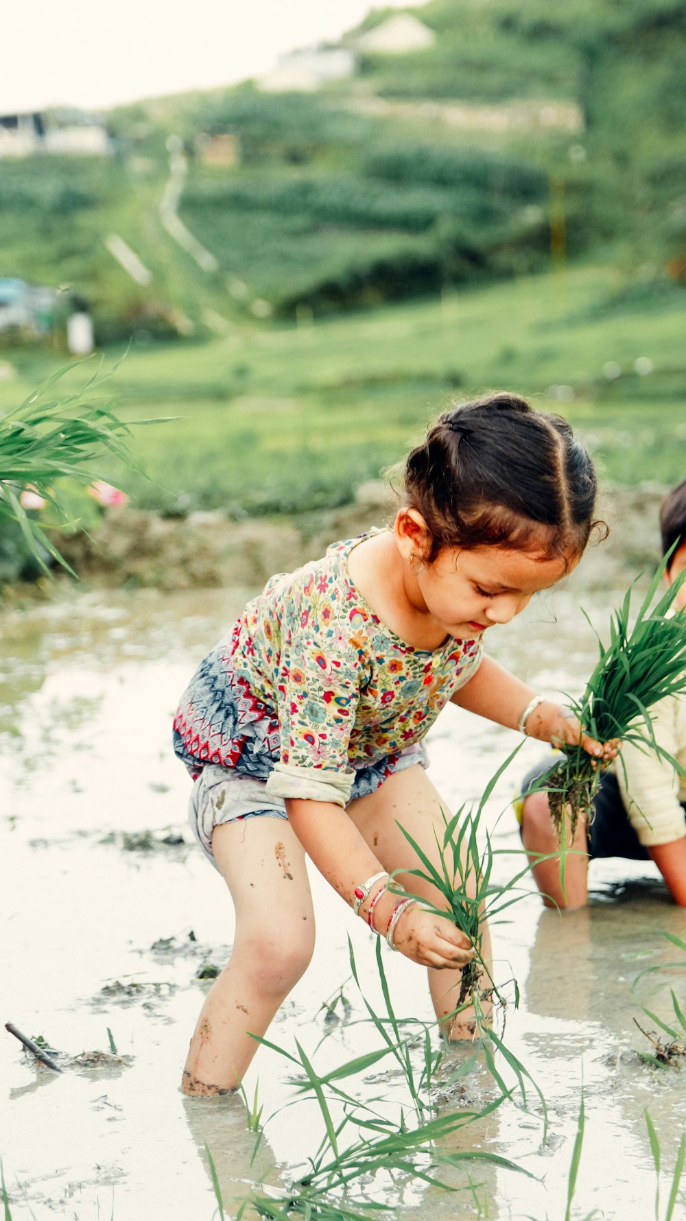 a young girl planting plants in a field