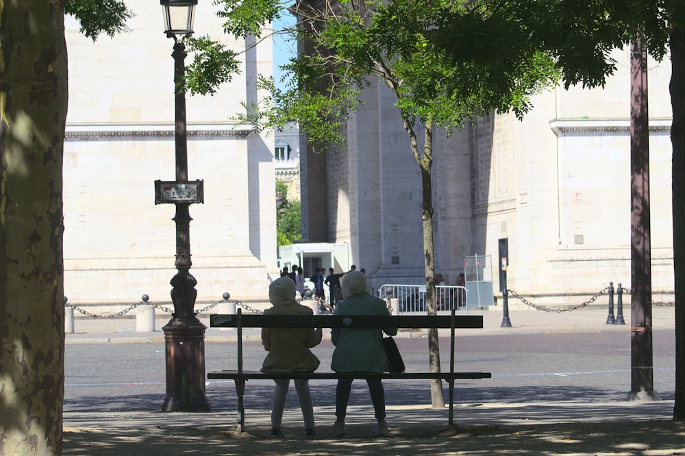 a couple of people sit on a bench
