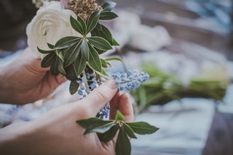 Hands holding a small bouquet of fresh flowers symbolizing care and growth.