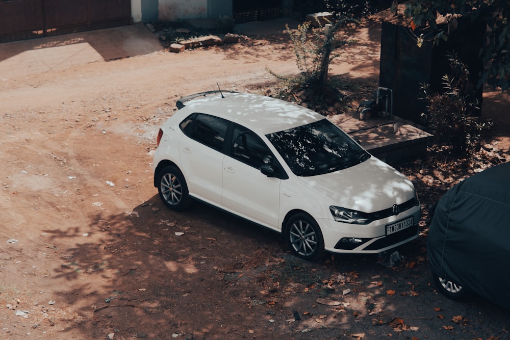 a white car parked on a dirt road