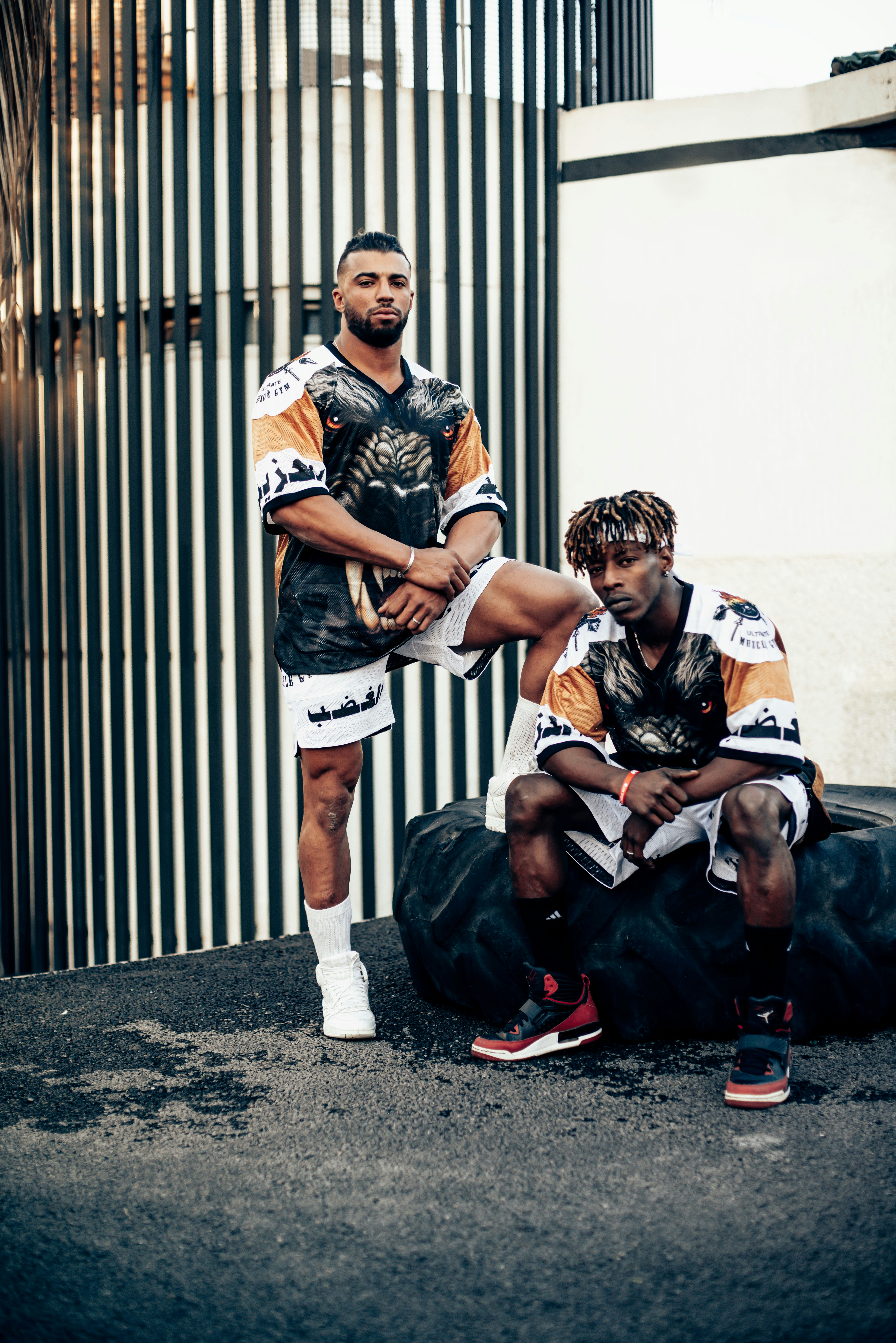 a man kneeling next to a man in a basketball uniform