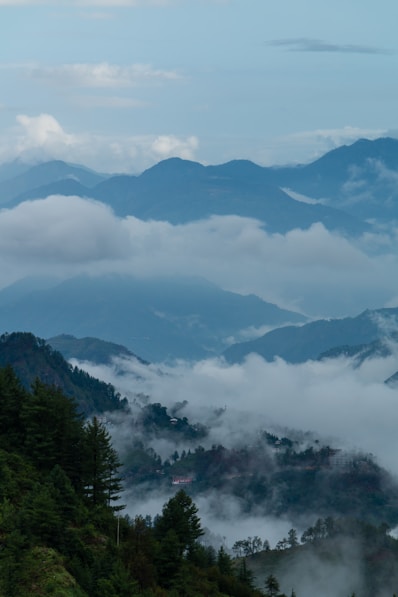 a view of a mountain range with clouds and trees