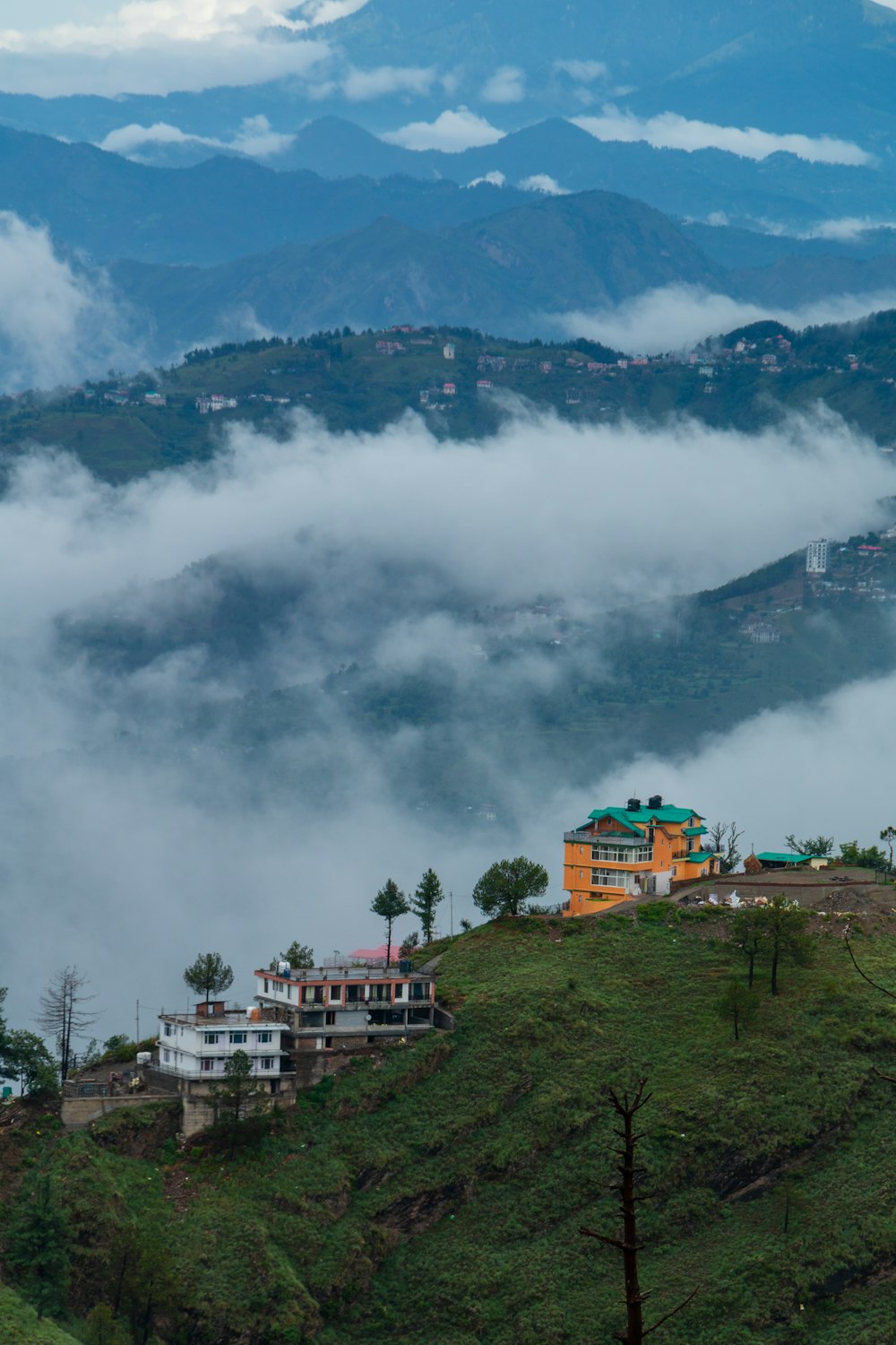 a building on a hill with clouds in the background