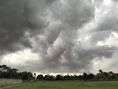 A group of players building a fortified base under a stormy sky.
