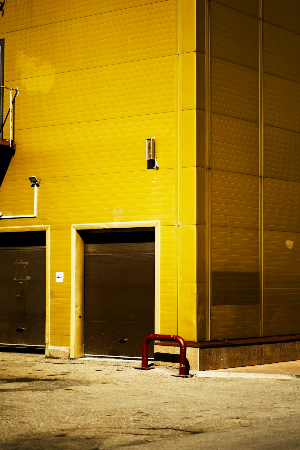 a yellow building with a red bench