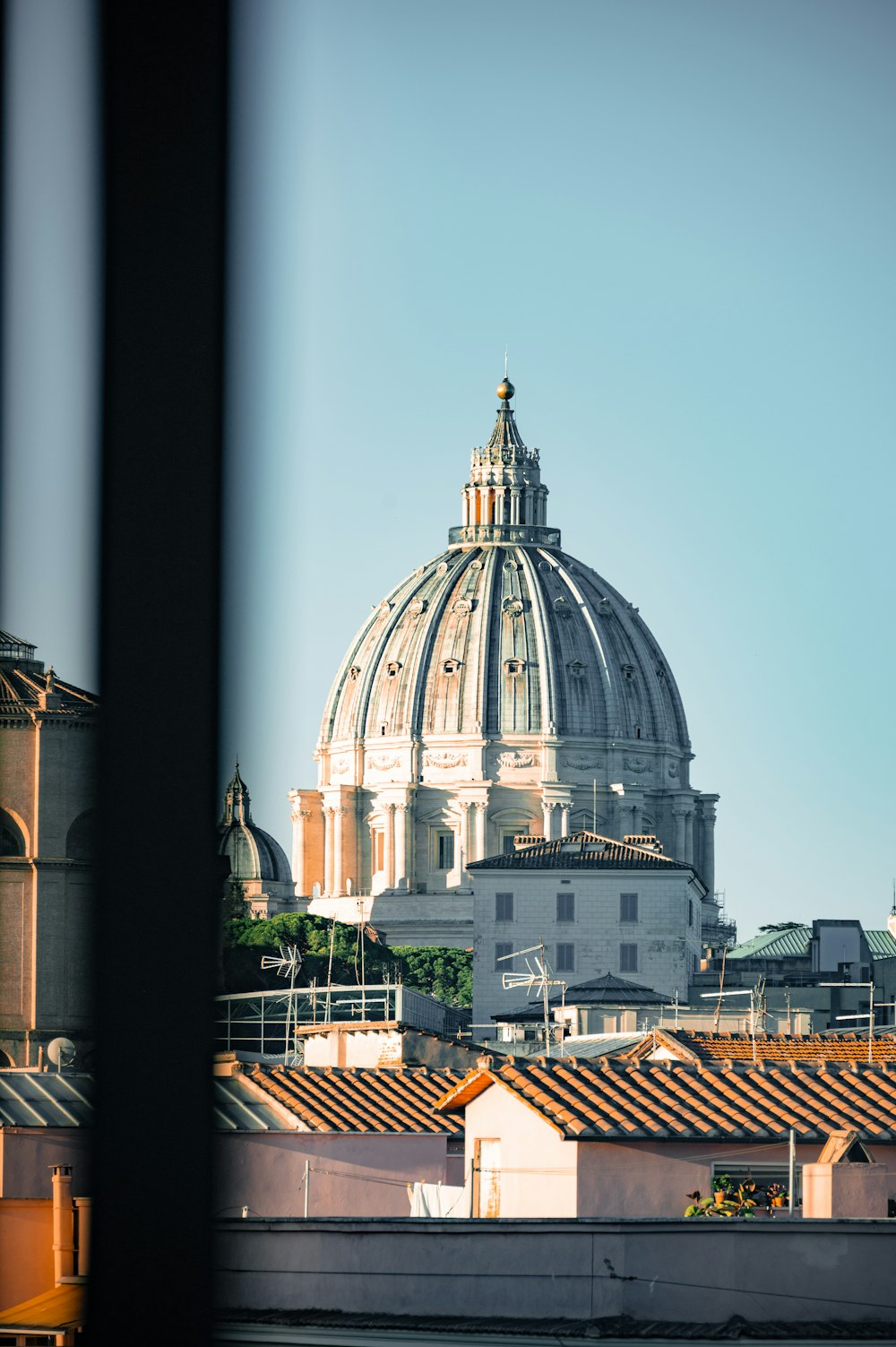 un edificio a cupola con una cupola con la Basilica di San Pietro sullo sfondo