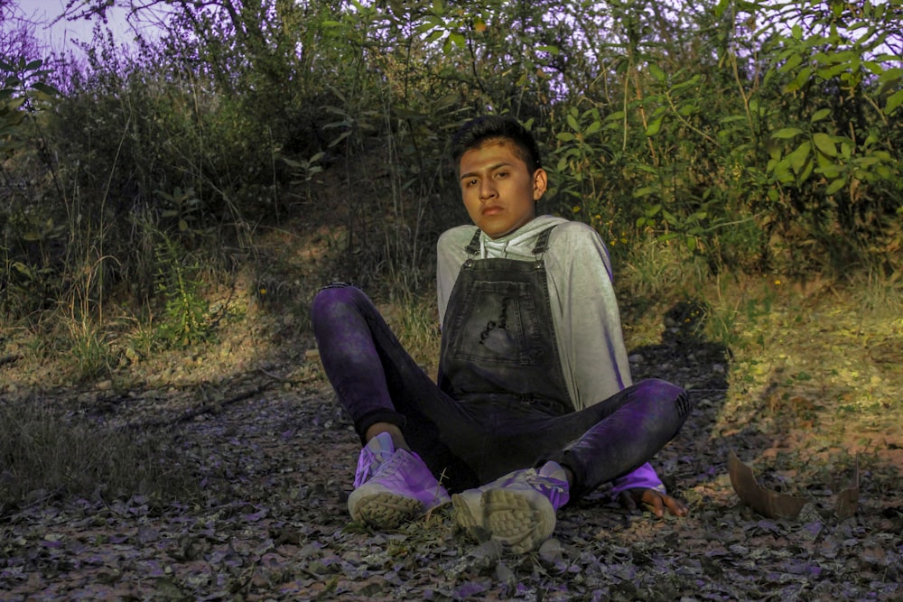 a boy sitting on the ground reading a book