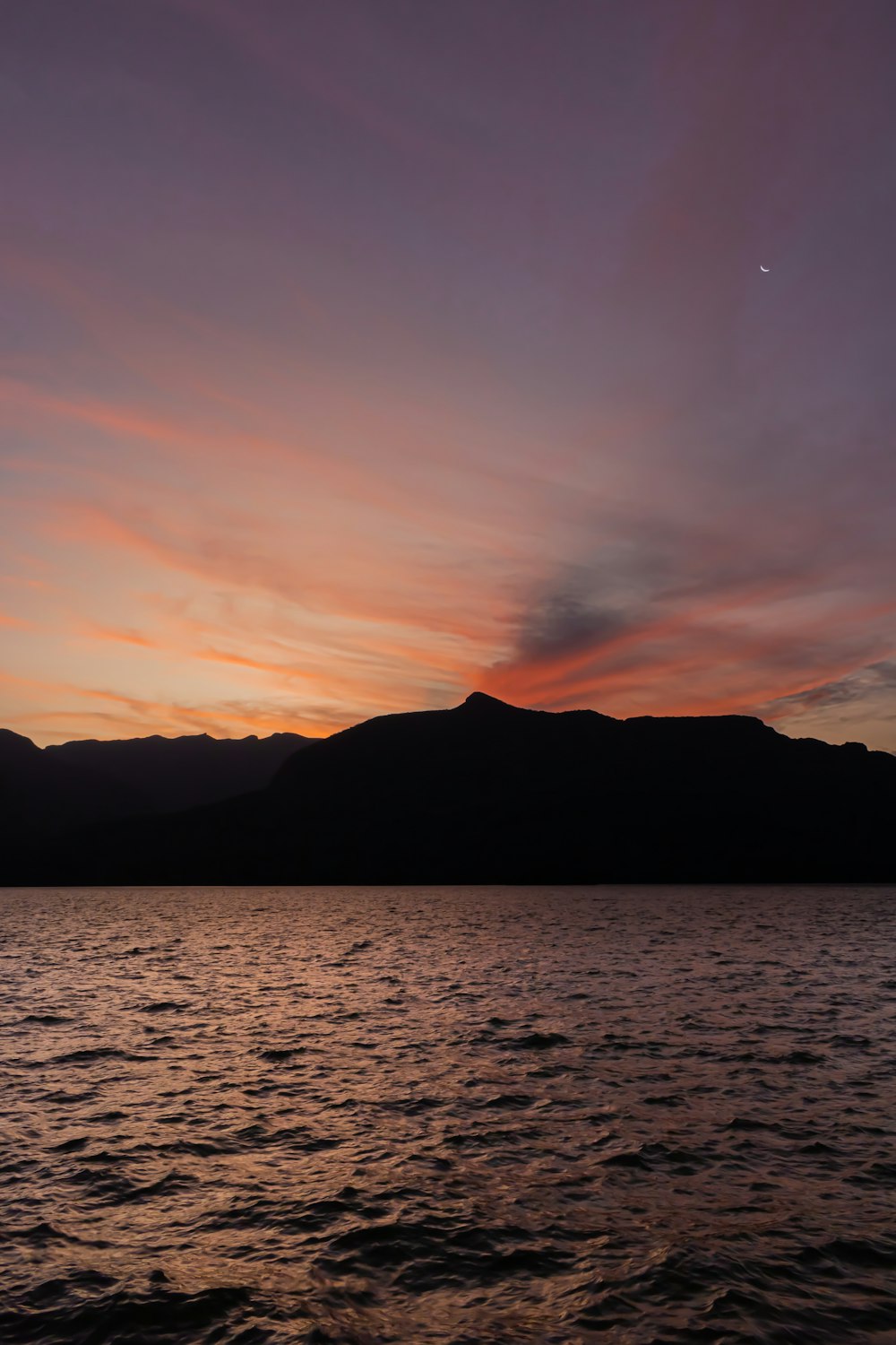 a body of water with a mountain in the background