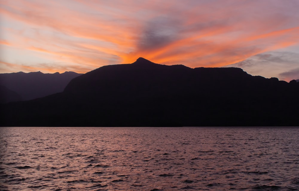 a body of water with a mountain in the background