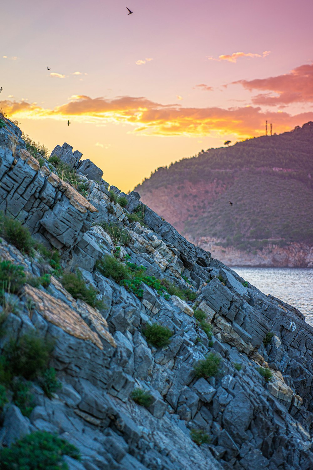 una scogliera rocciosa con un tramonto