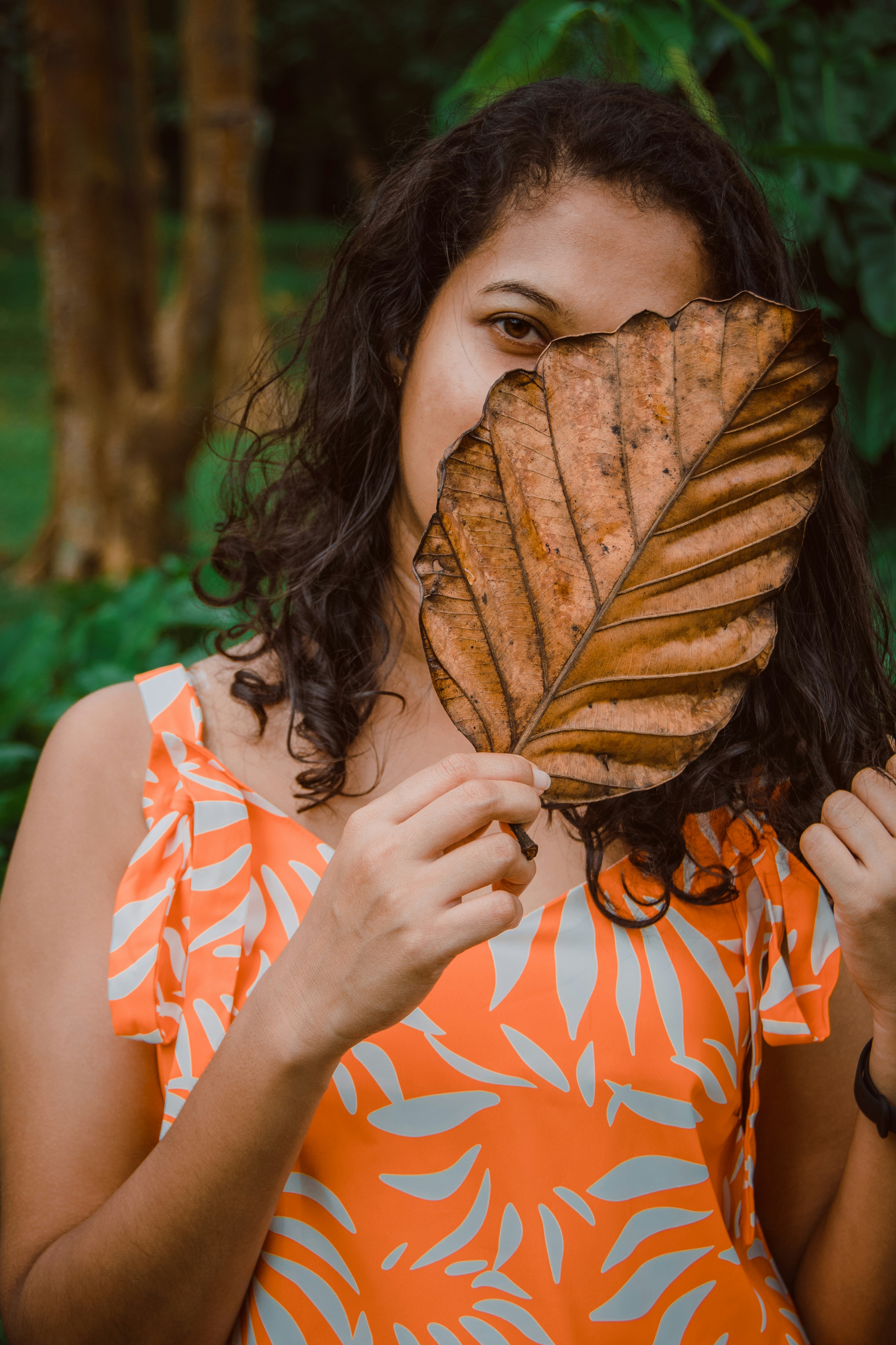a person holding a large orange and black snake