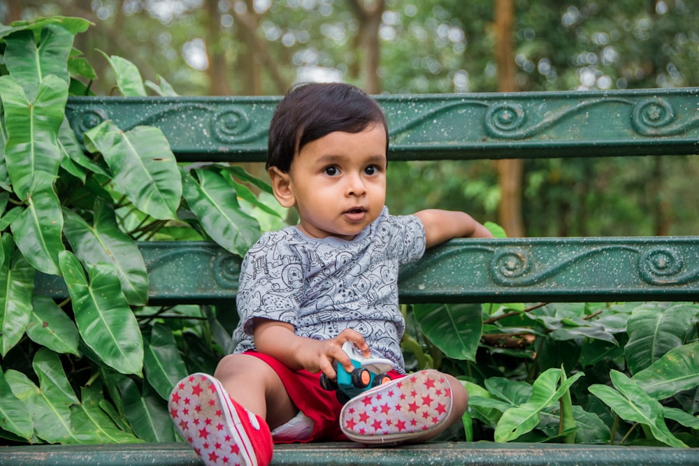 a baby sitting on a bench