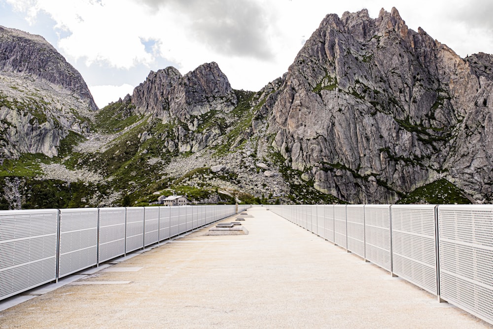 a road with a fence and a mountain in the background