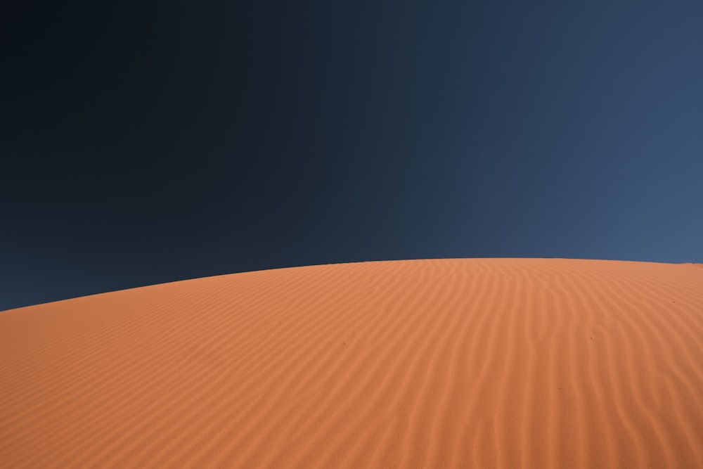 Une dune de sable avec un ciel bleu