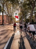 Cyclists riding through a green city street promoting eco-friendly transportation.