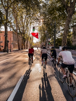 Cyclists riding through a green city street promoting eco-friendly transportation.