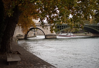 a boat sailing under a bridge