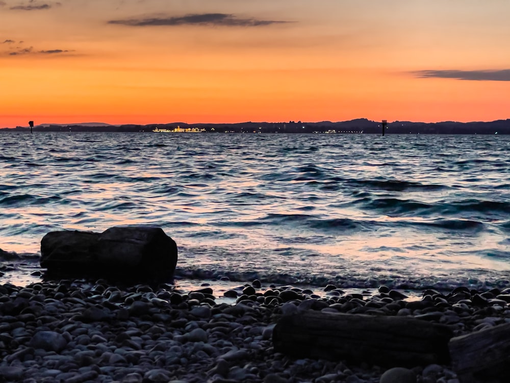 a rocky beach with a lighthouse in the distance