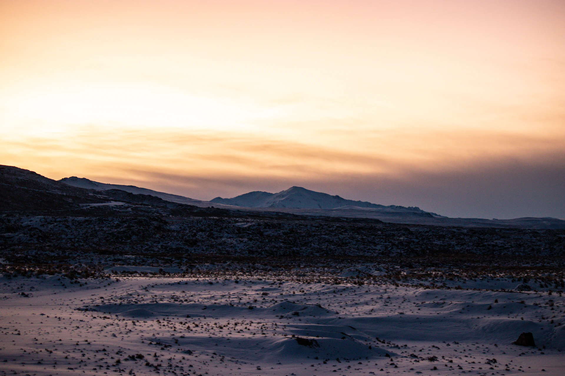 a snowy landscape with mountains in the background
