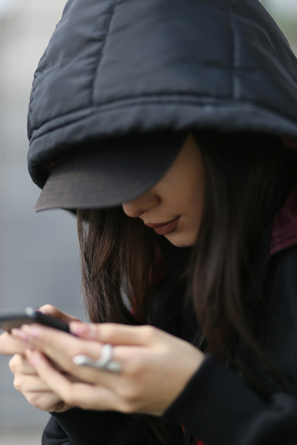 a woman wearing a hat and looking at her phone