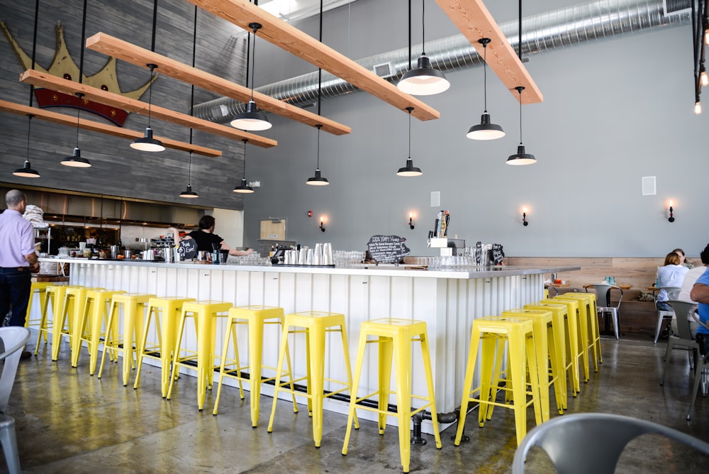 a group of people sitting at a table with yellow stools