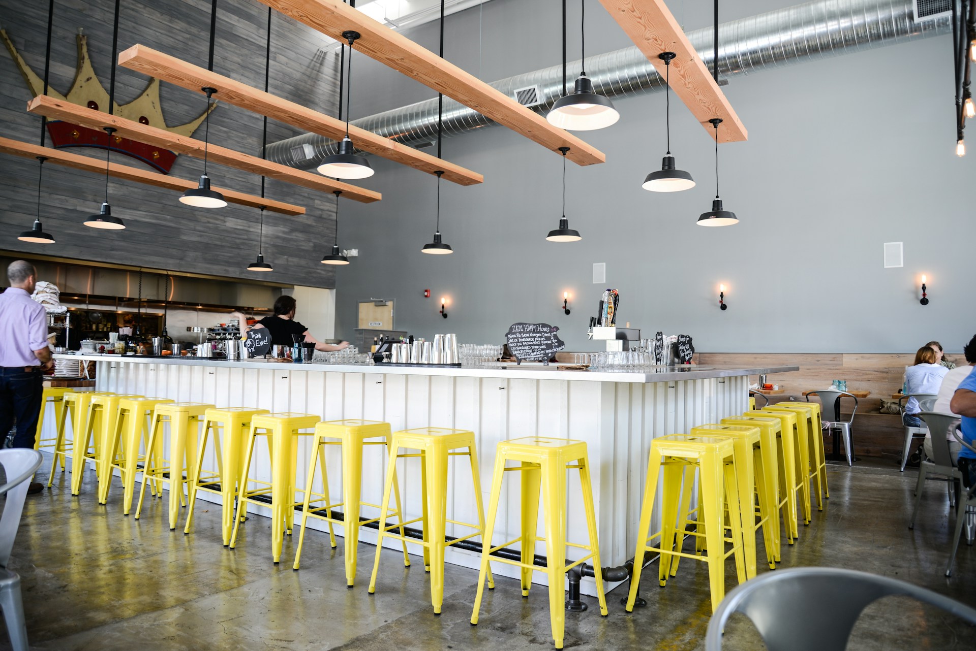 a group of people sitting at a table with yellow stools