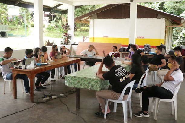 A diverse group of students engaged in a collaborative public health discussion outdoors.