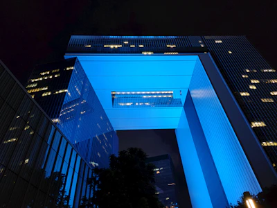 Evening shot of the council’s headquarters illuminated with blue and cyan lighting, symbolizing innovation.