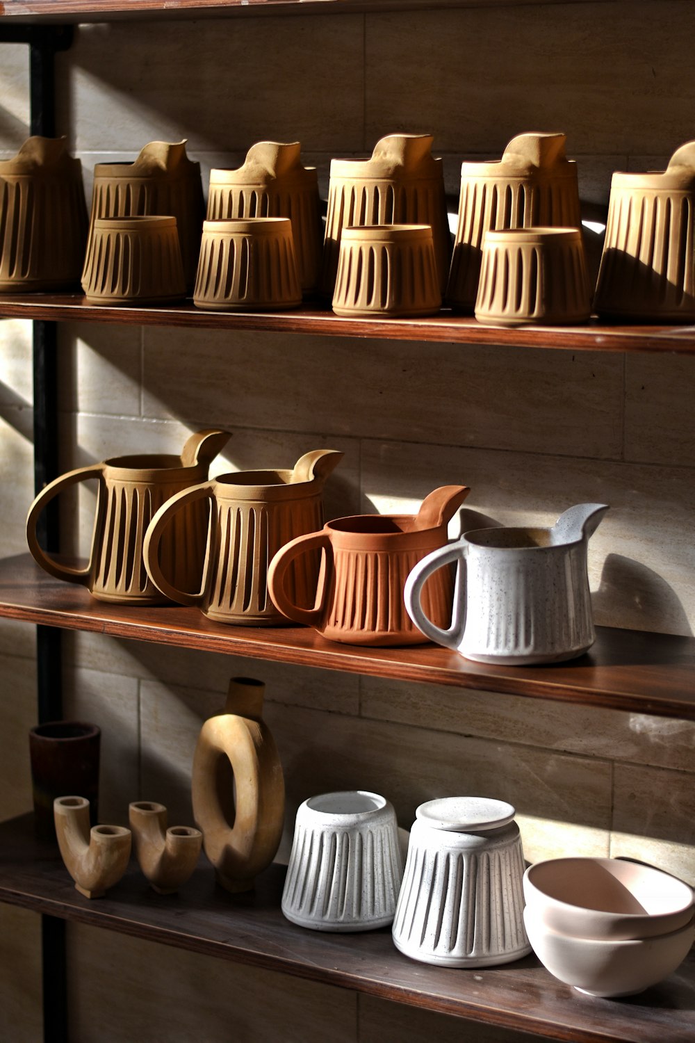 a shelf with tea cups and teapots on it