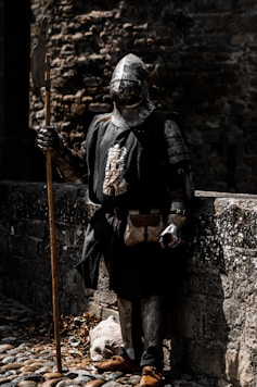 a person in a garment holding a stick