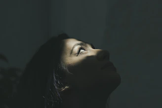 Elegant side profile highlighting subtle facial contouring with soft shadows and a nude beige background.