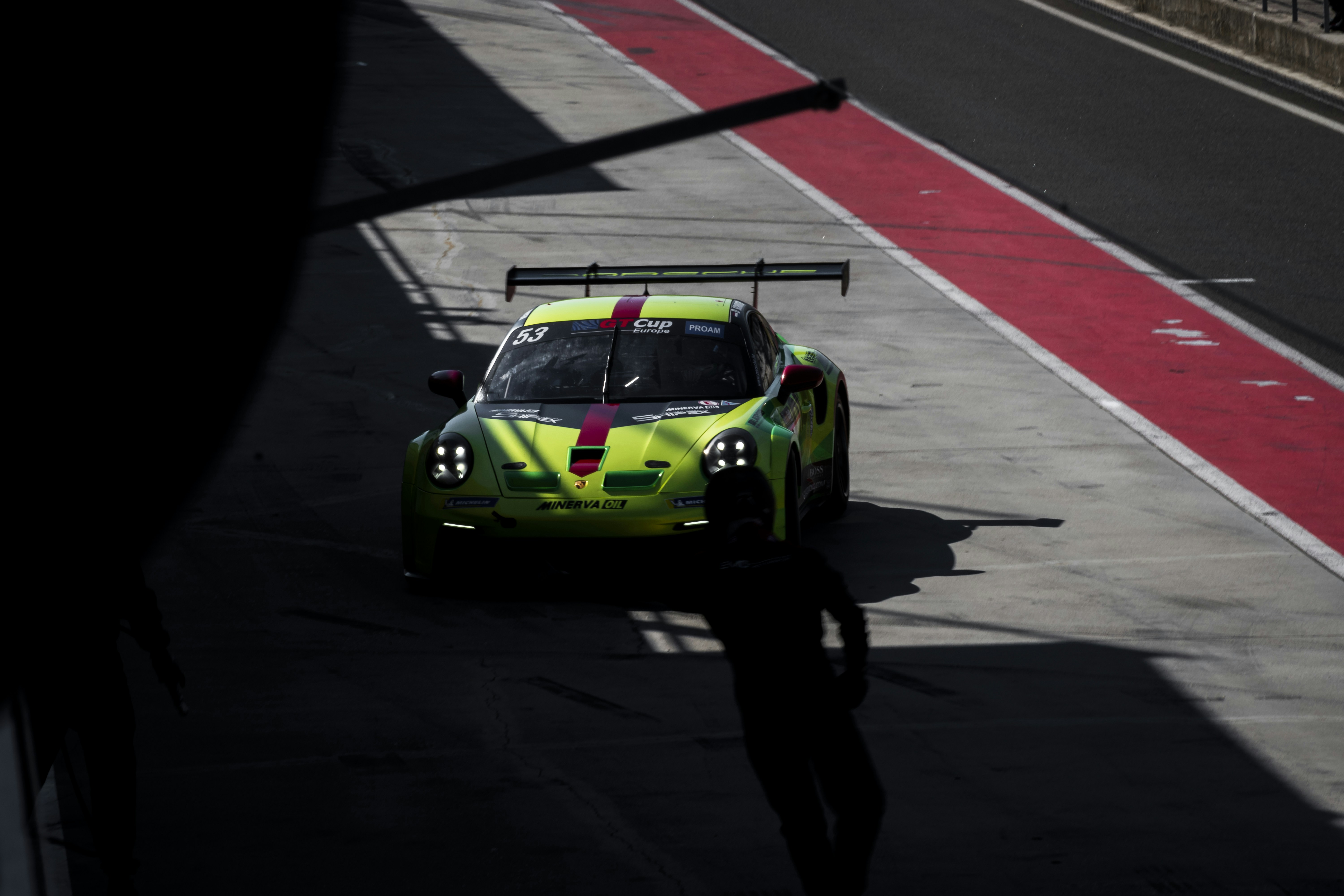 A person standing next to a race car on a track photo – Free ...