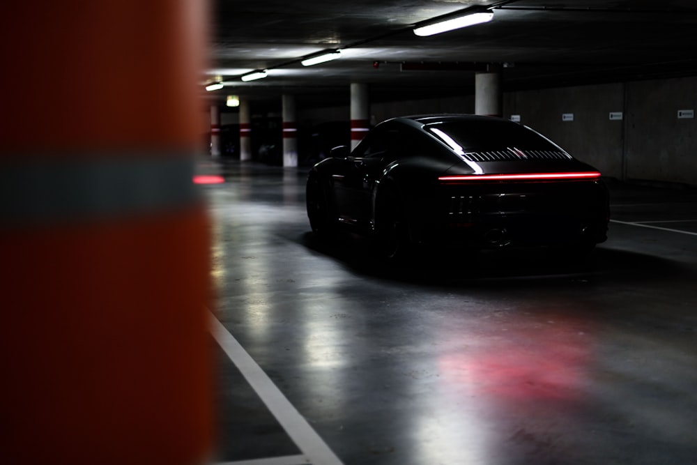 a black sports car parked in a parking garage