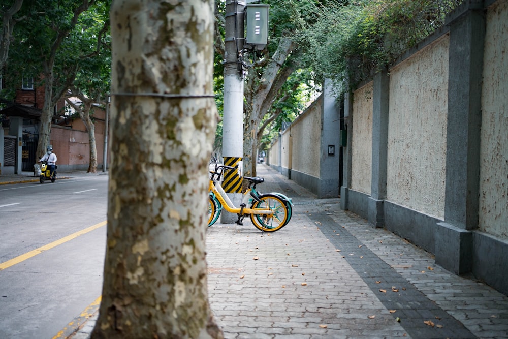 a yellow bike parked on the side of a street