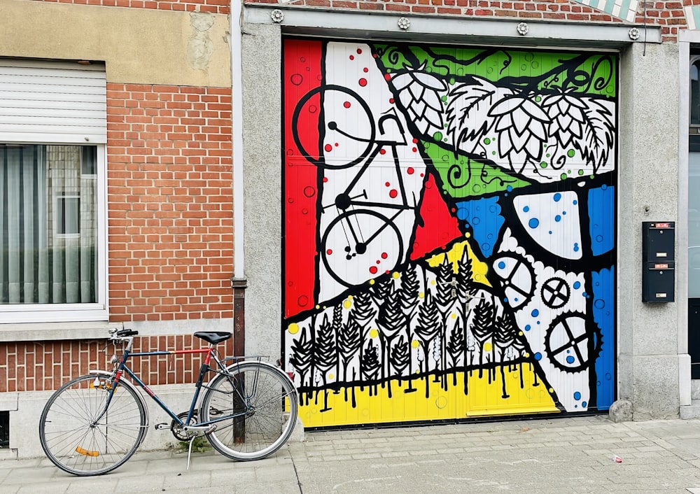 a bicycle parked next to a wall with graffiti