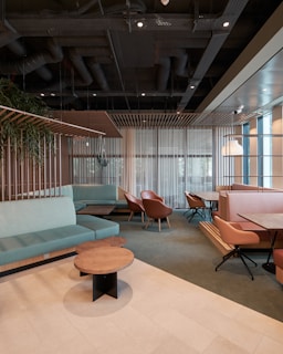 A minimalist lounge area with sleek, muted green accents overlooking the playing fields.