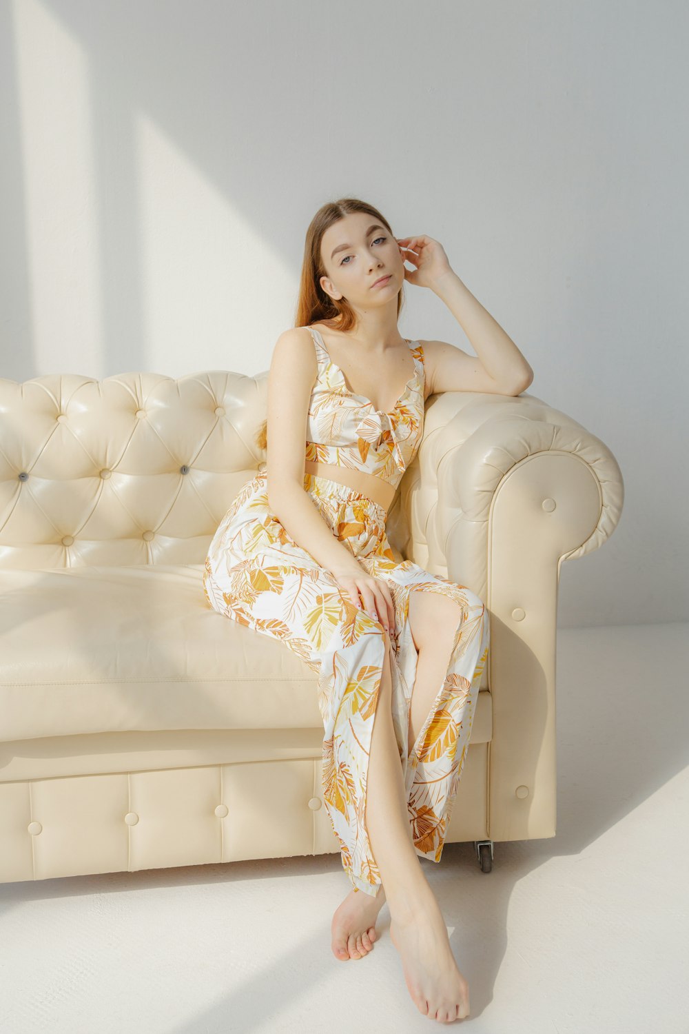 a woman in a dress sitting on a couch