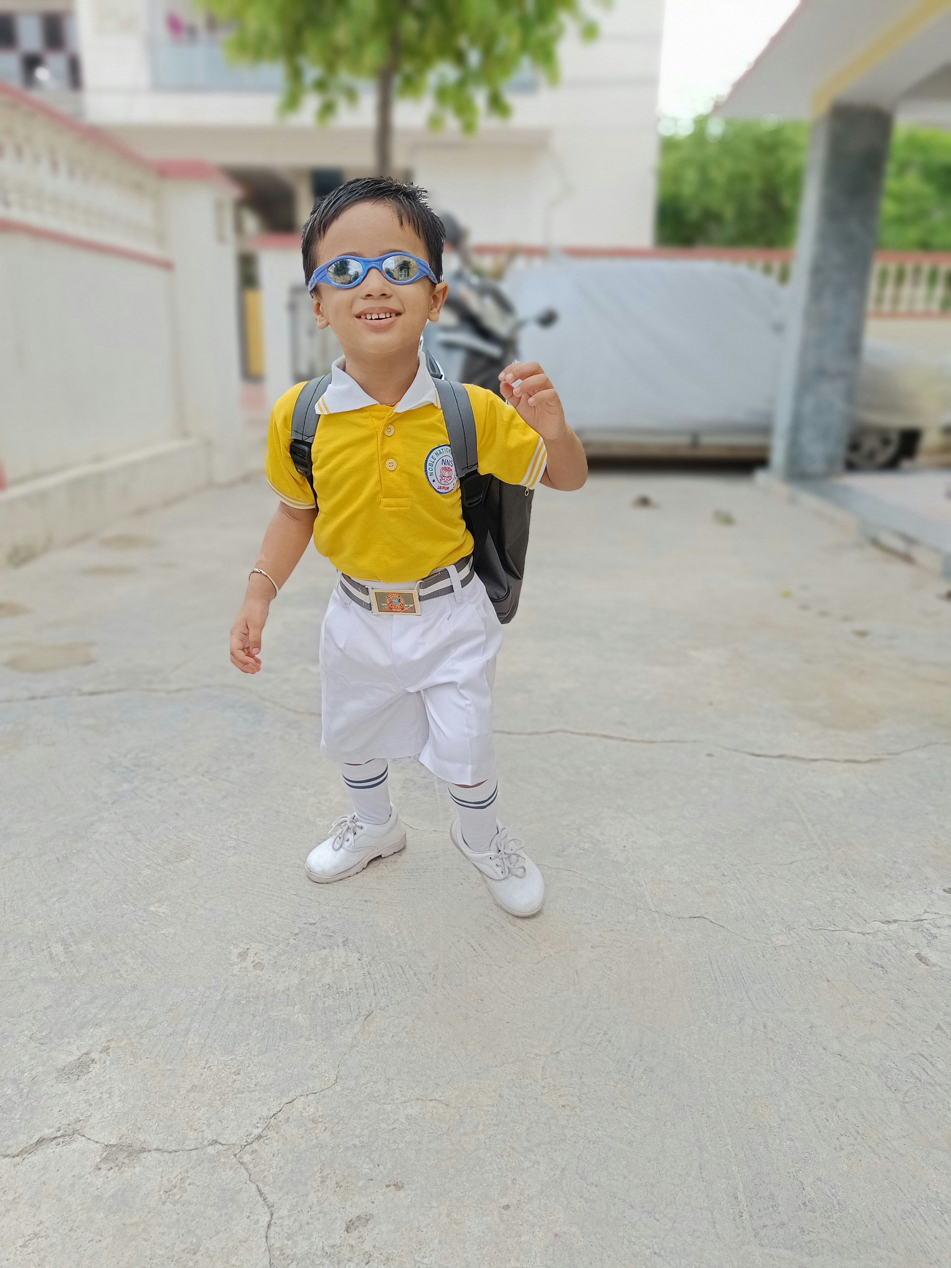 a boy wearing a backpack and sunglasses